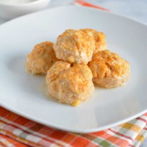 Buffalo Ground Chicken Meatballs on a white plate with an orange plaid napkin.